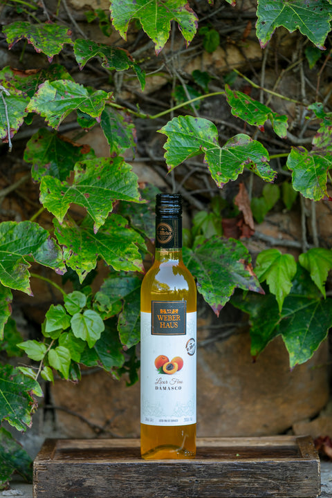 Garrafa de Licor Fino Weber Haus de Damasco 500ml em ambiente externo.
