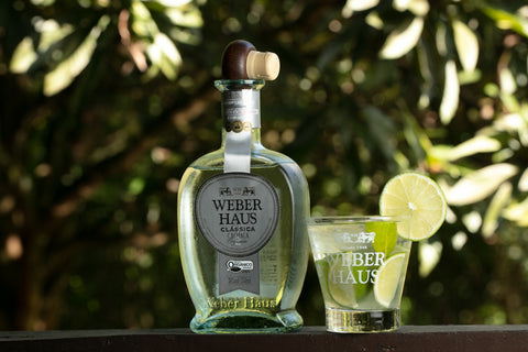 Cachaça Prata Clássica Weber Haus em foto ambientada acompanhada de uma caipirinha, feita utilizando essa mesma cachaça.