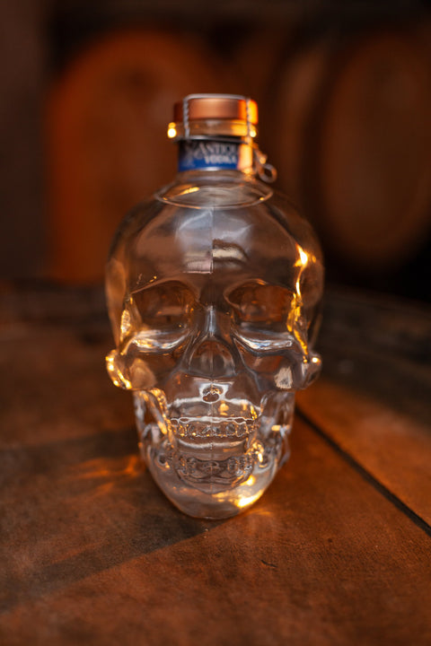 Garrafa de Vodka Antiqua 750ml no formato de caveira ambientada em barril de madeira.