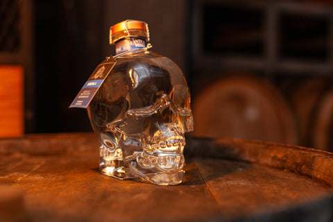 Garrafa de Vodka Antiqua 750ml no formato de caveira ambientada em barril de madeira.