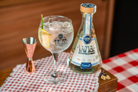 Garrafa de Dry Gin WH48 servido com drink Gin Tônica.