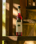 Garrafa de Licor Fino Weber Haus de Cassis em cor avermelhada.