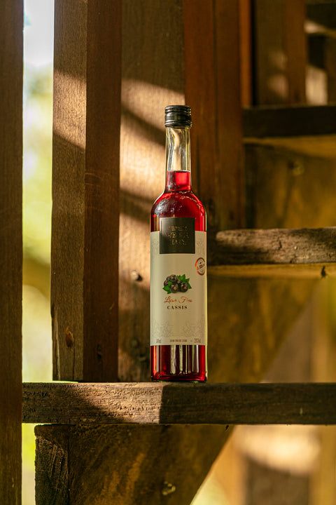 Garrafa de Licor Fino Weber Haus de Cassis em cor avermelhada.
