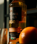 Cachaça ambientada com zoom no rotulo e laranja perto da camera