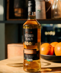 Cachaça Amburana Weber Haus em uma mesa ao lado de laranjas