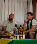 Dois homens olhando jogos com duas garrafas e cima de uma mesa na frente deles