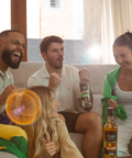 Grupo de pessoas comemorando jogos com uma garrafa na mão e outra em uma mesa