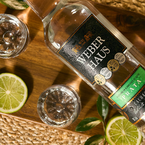 Cachaça ambientada com fatias de limões e copos espalhados por perto