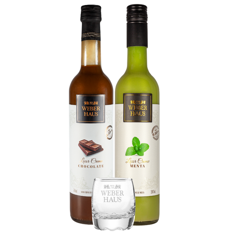 Licor de menta e de chocolate paradas uma do lado da outra com um copo de shot na frente em um fundo branco