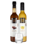 Duas garrafas de licores, maracujá e chocolate, com um copo de shot na frente e um fundo branco