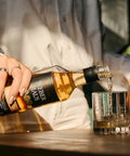 Cachaça sendo servida em um copo por uma mulher